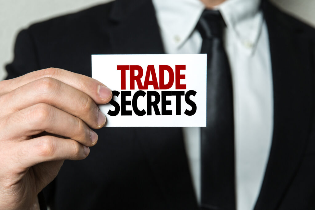 Business man holding a sign that says "Trade Secrets" for a case involving trade secret protection - Finkel Law Group